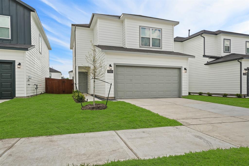 a front view of a house with a yard and garage