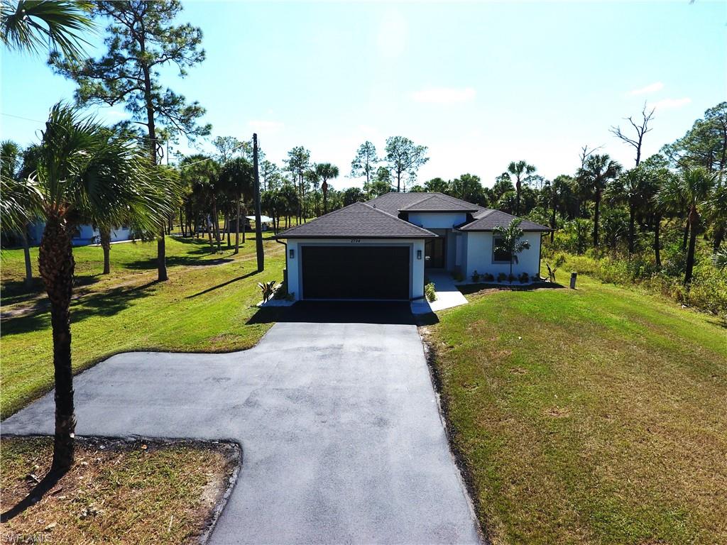 a view of a house with a yard and a garage