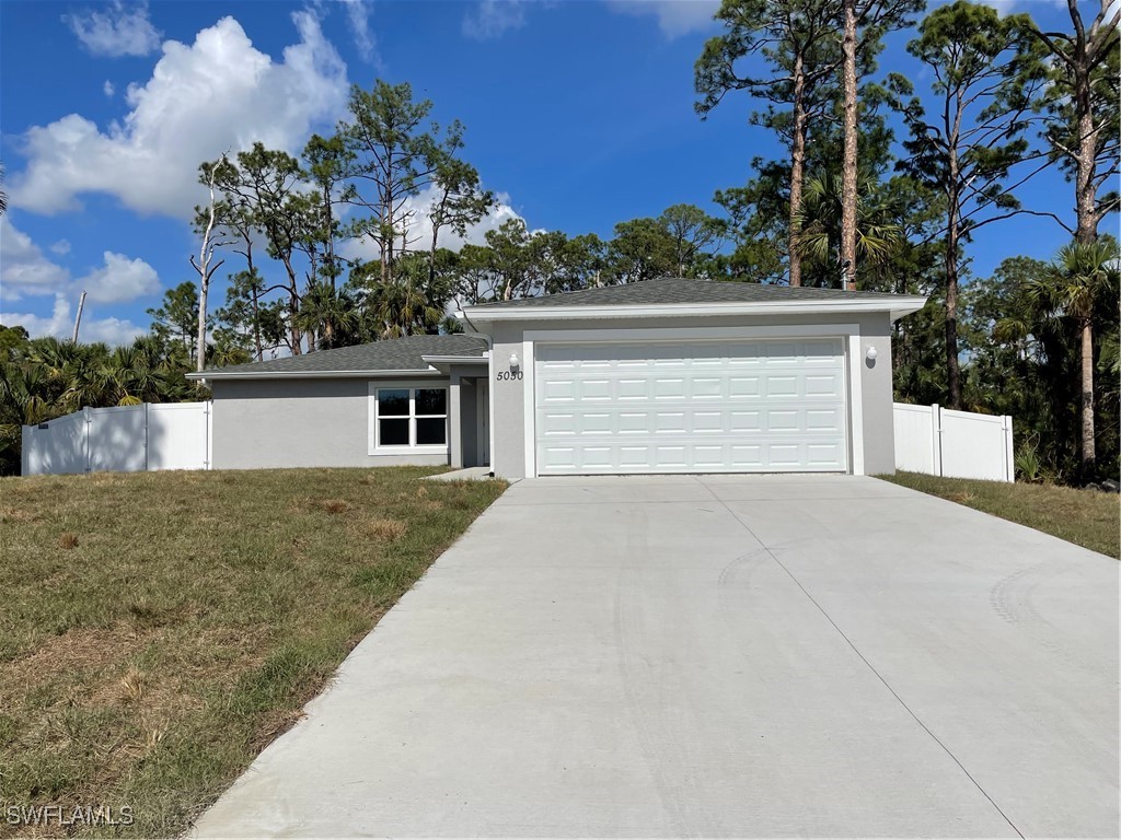 front view of house with a yard and trees