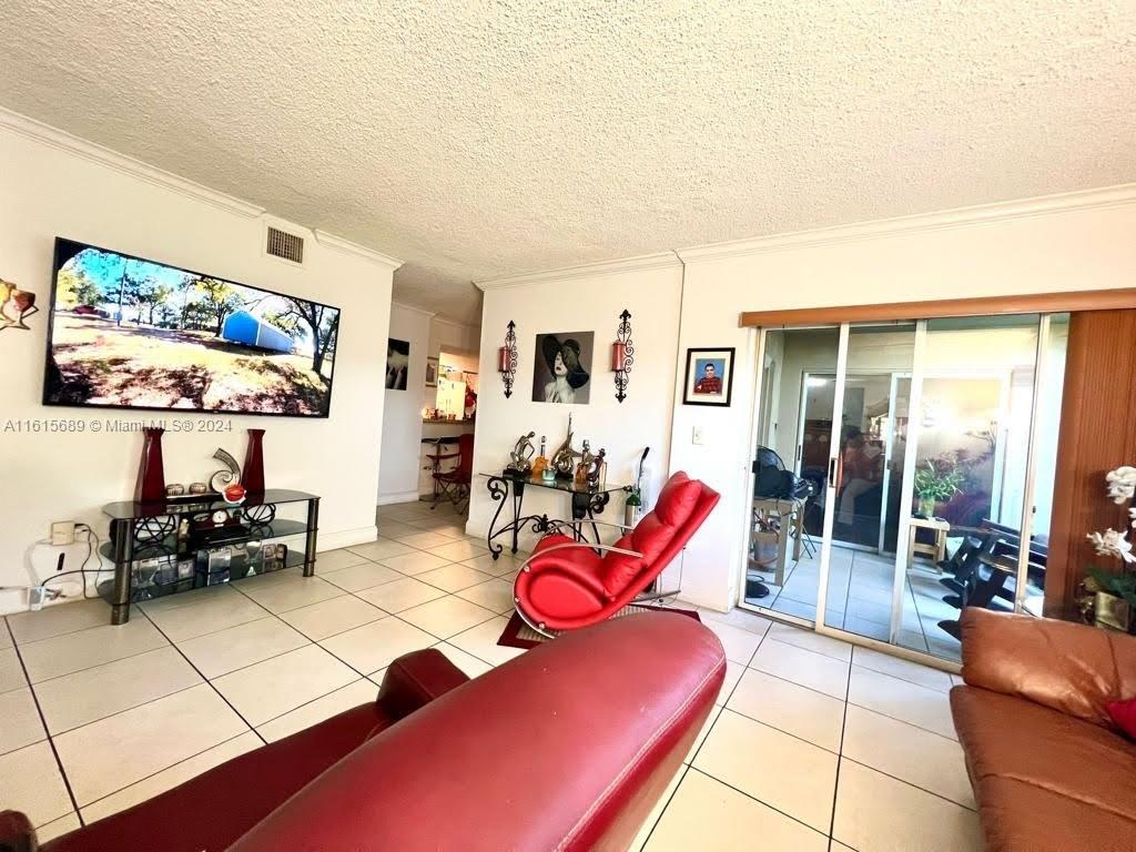 a living room with furniture a flat screen tv and a floor to ceiling window