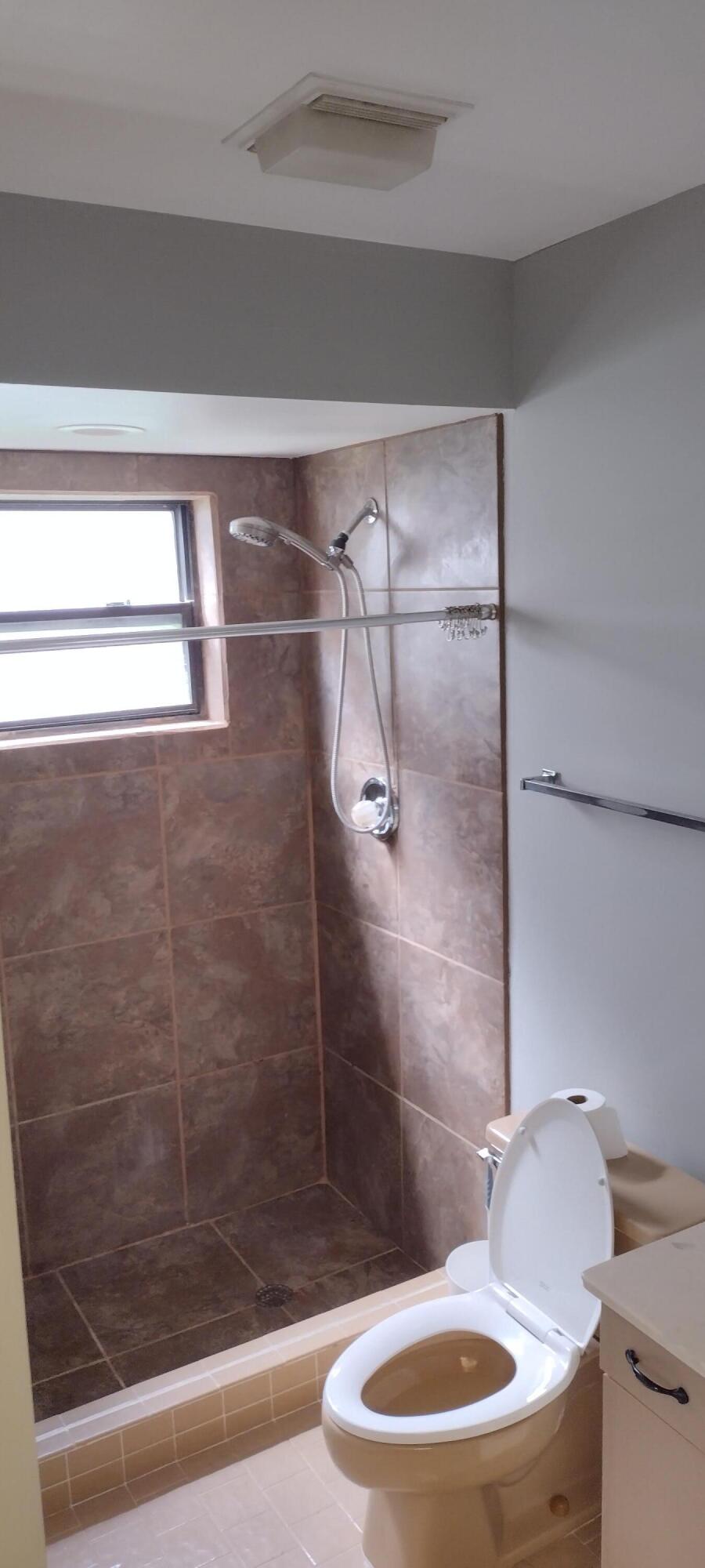 a bathroom with a toilet and a shower