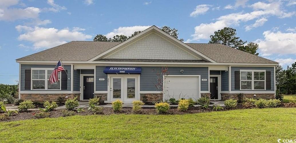 Craftsman-style home with a garage and a front law