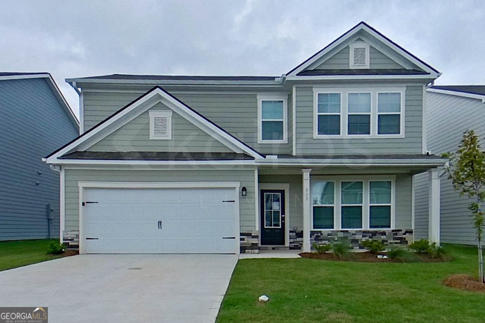 a front view of a house with a yard and garage