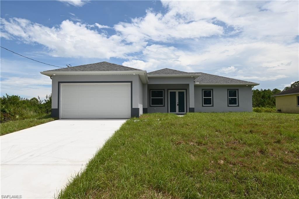 View of front of house featuring a front lawn and a garage