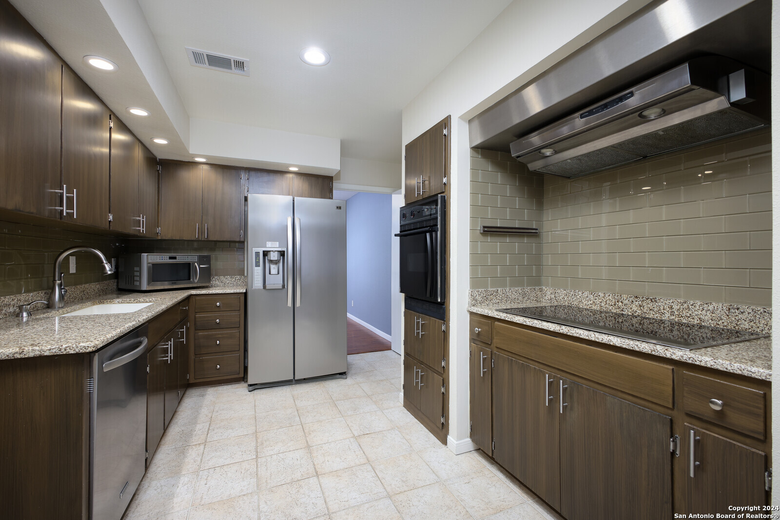 a kitchen with a sink stainless steel appliances and cabinets