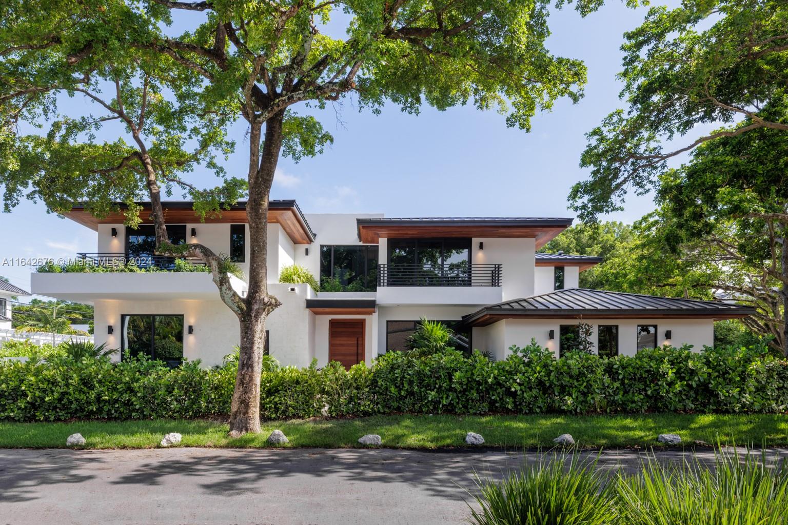 a front view of a residential houses with yard and green space