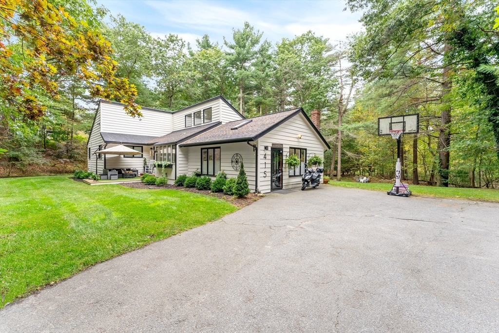 a front view of a house with a yard and trees