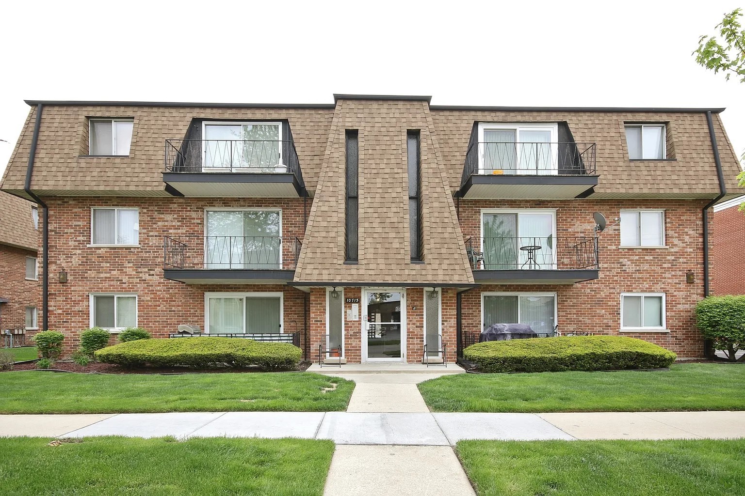 a front view of a brick house with a yard