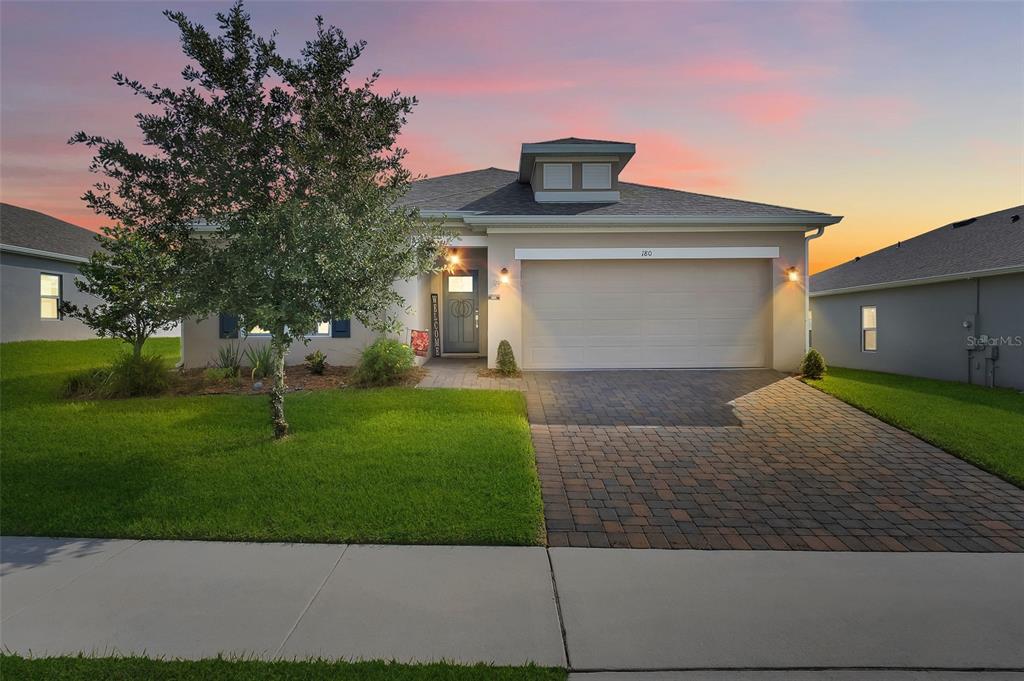 Arrive at your new home, highlighted by a paver driveway and meticulously manicured landscaping.