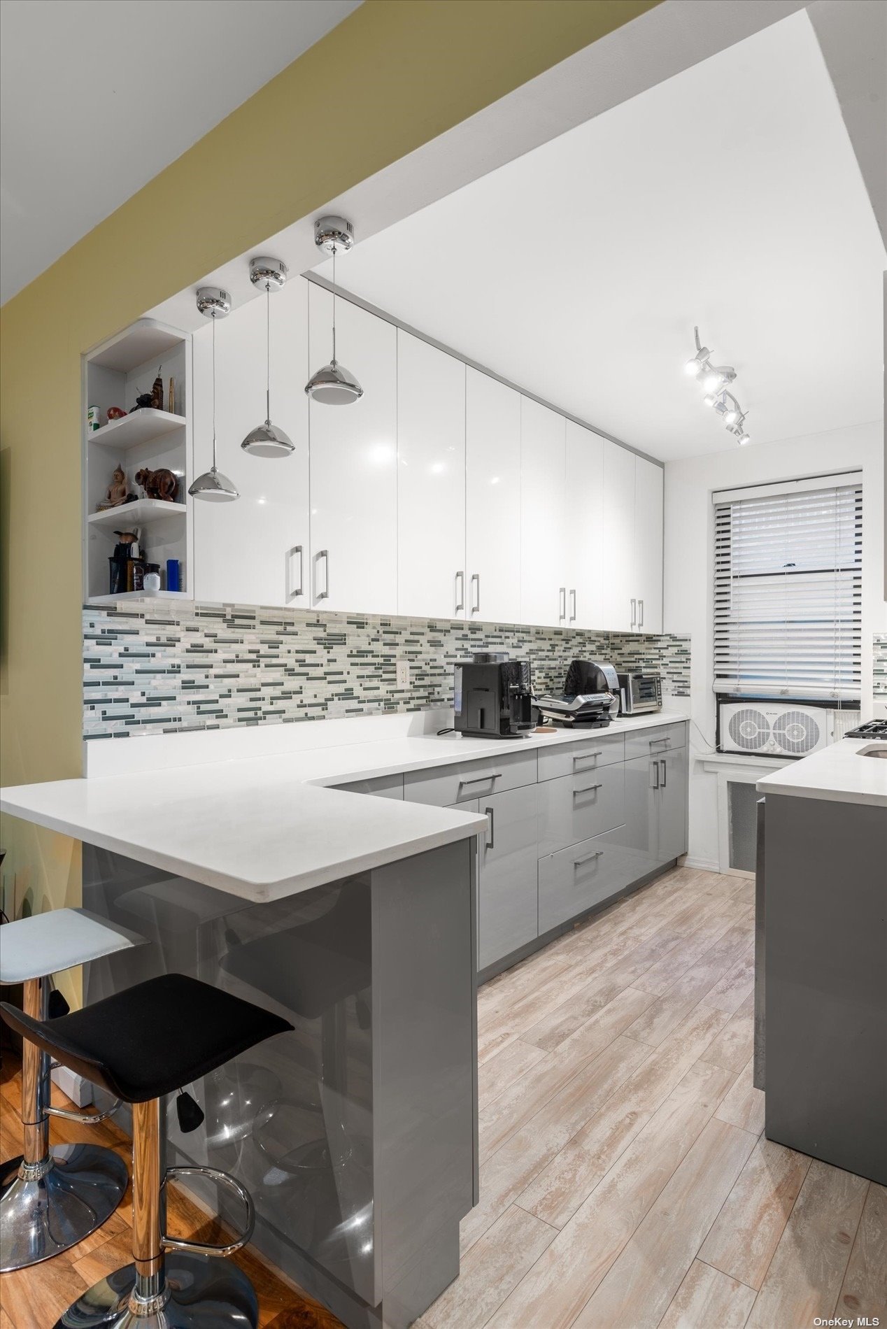 a kitchen with cabinets wooden floor and stainless steel appliances