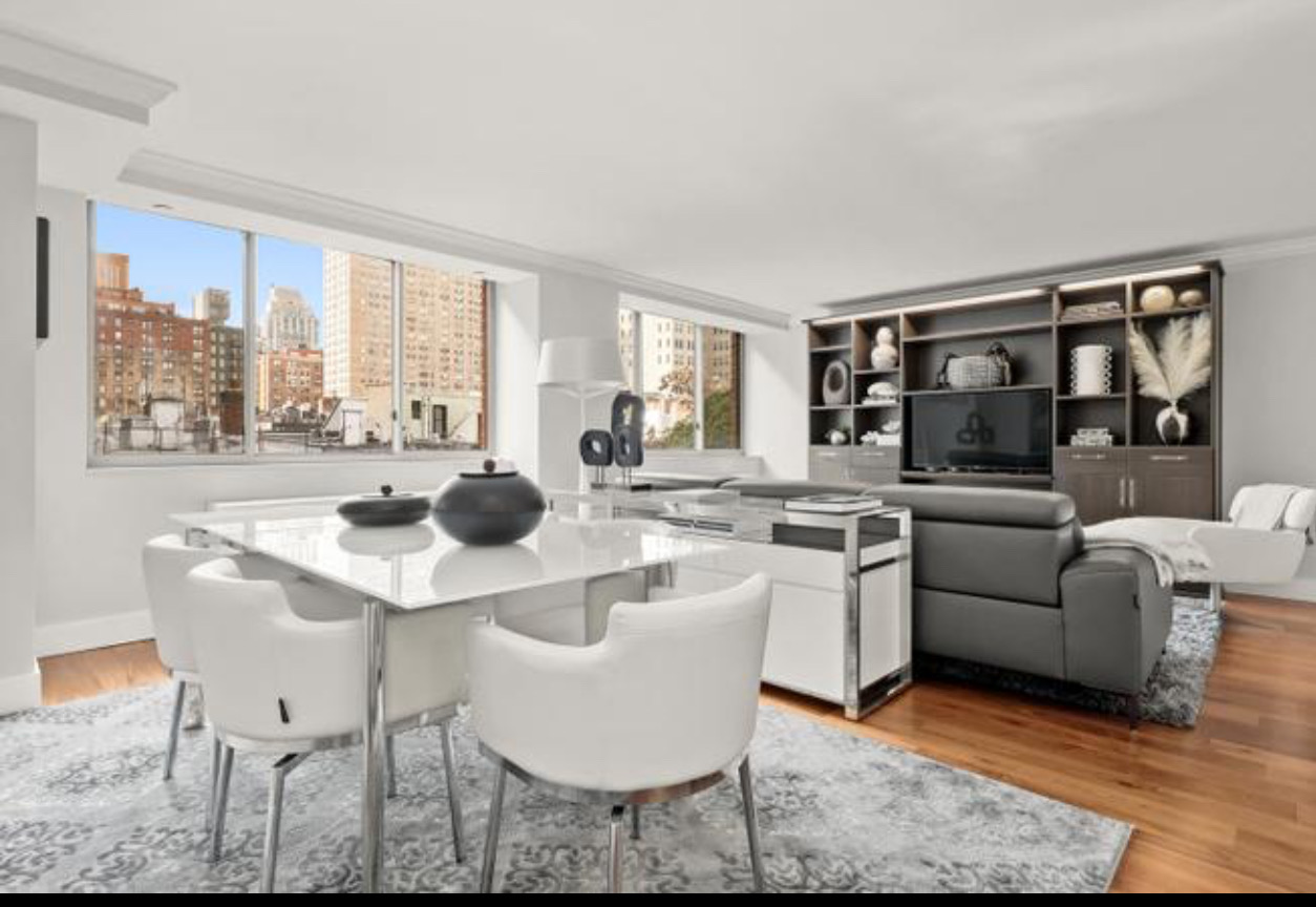 a living room with furniture a rug and a floor to ceiling window