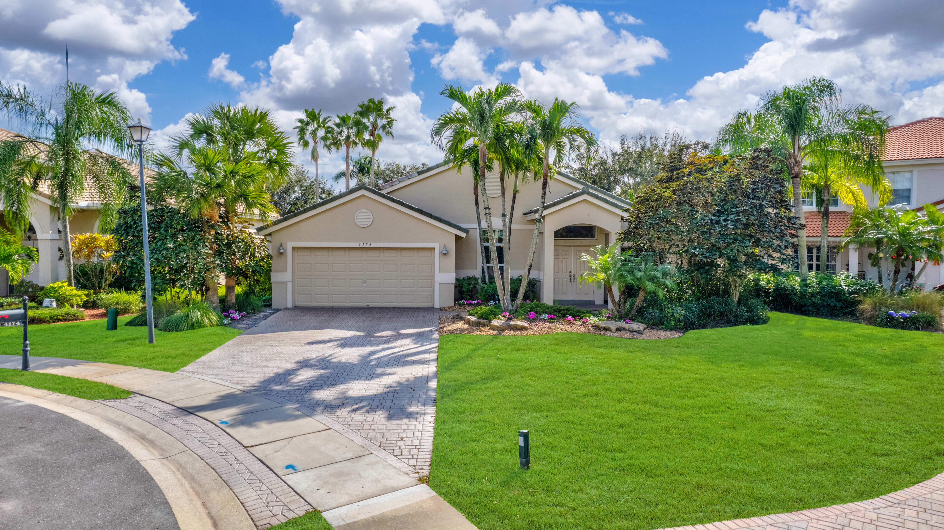 a front view of a house with a garden and trees