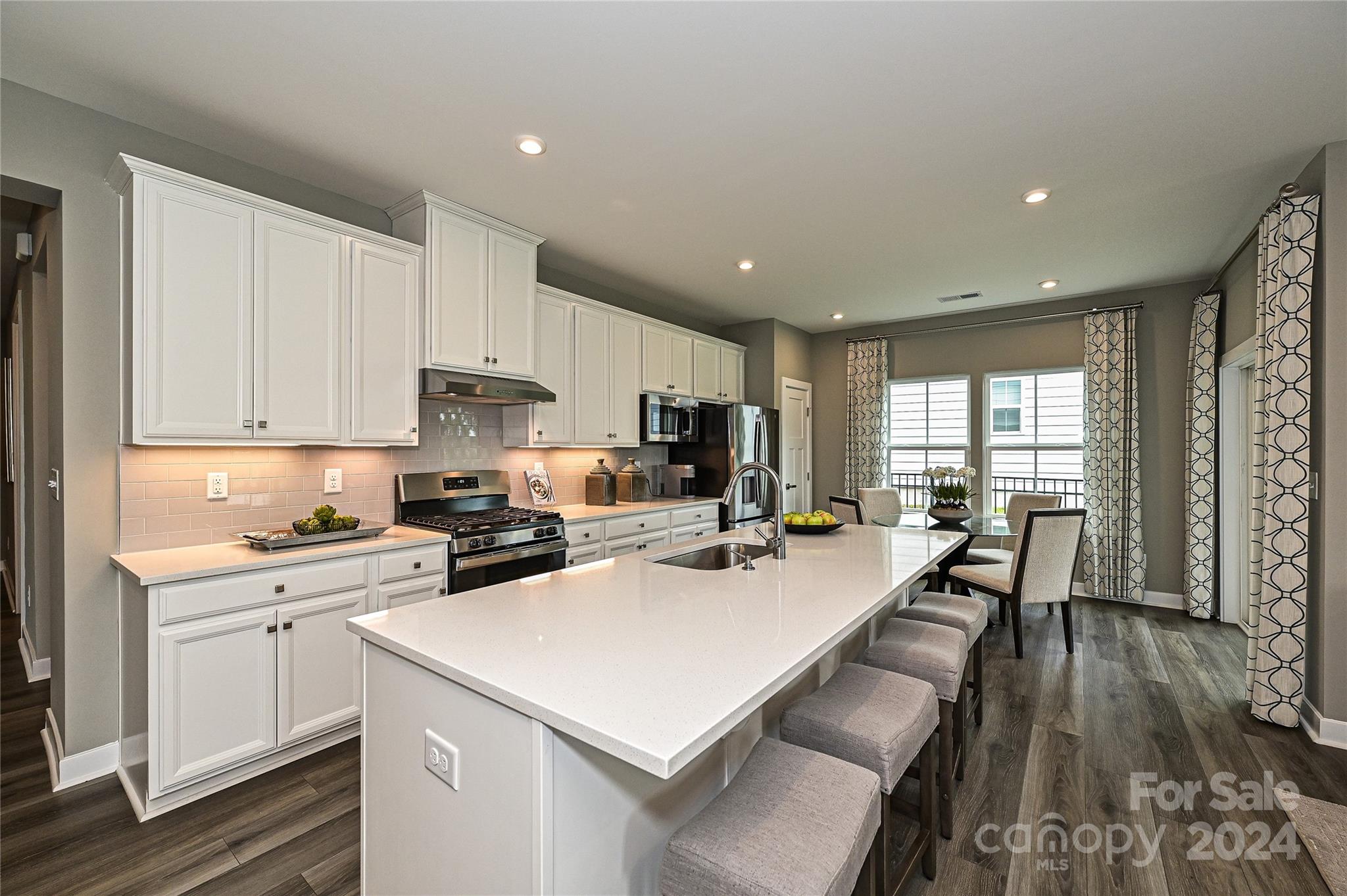 a kitchen with a stove a sink a refrigerator and cabinets