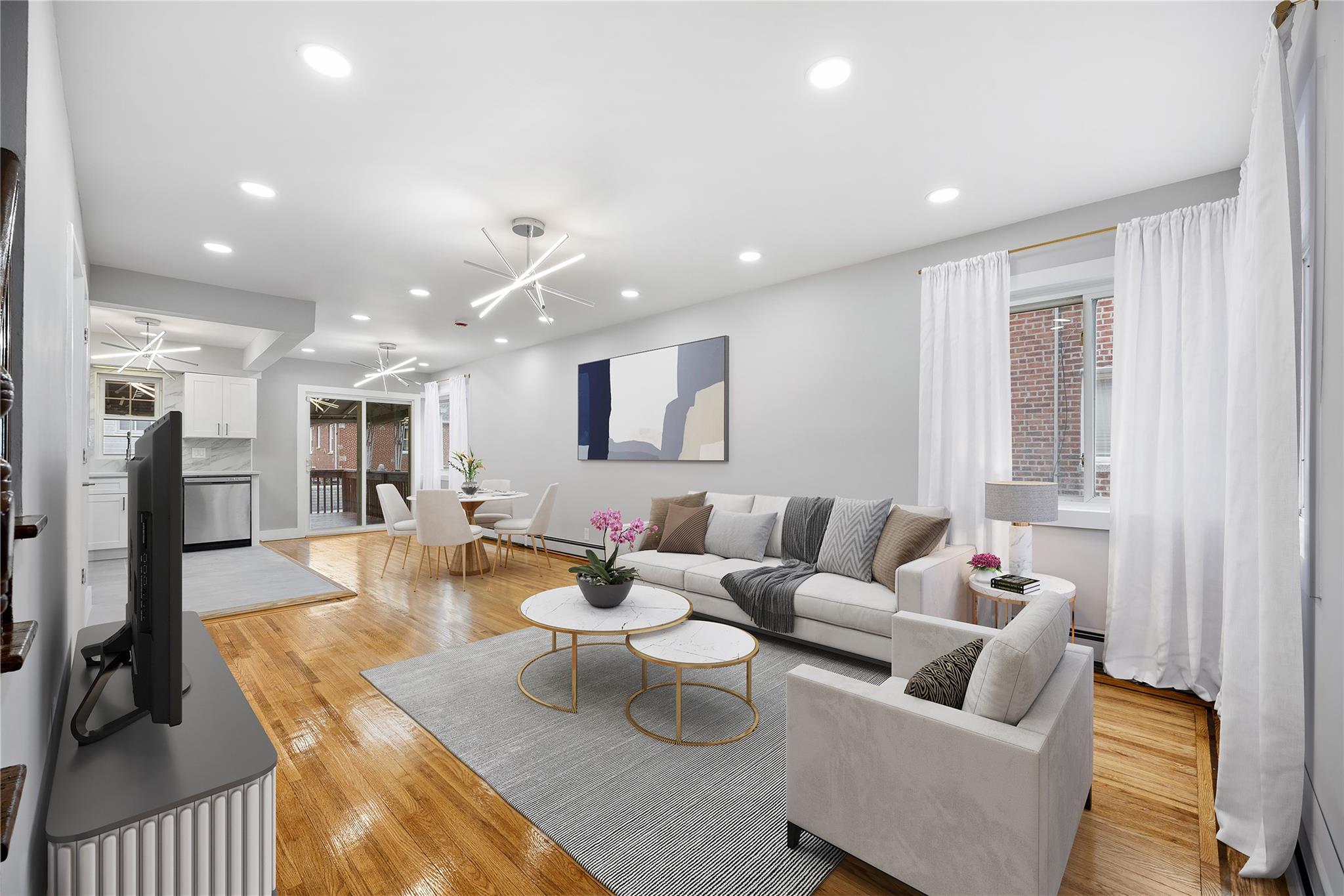 Living room with light hardwood / wood-style flooring and ceiling fan with notable chandelier