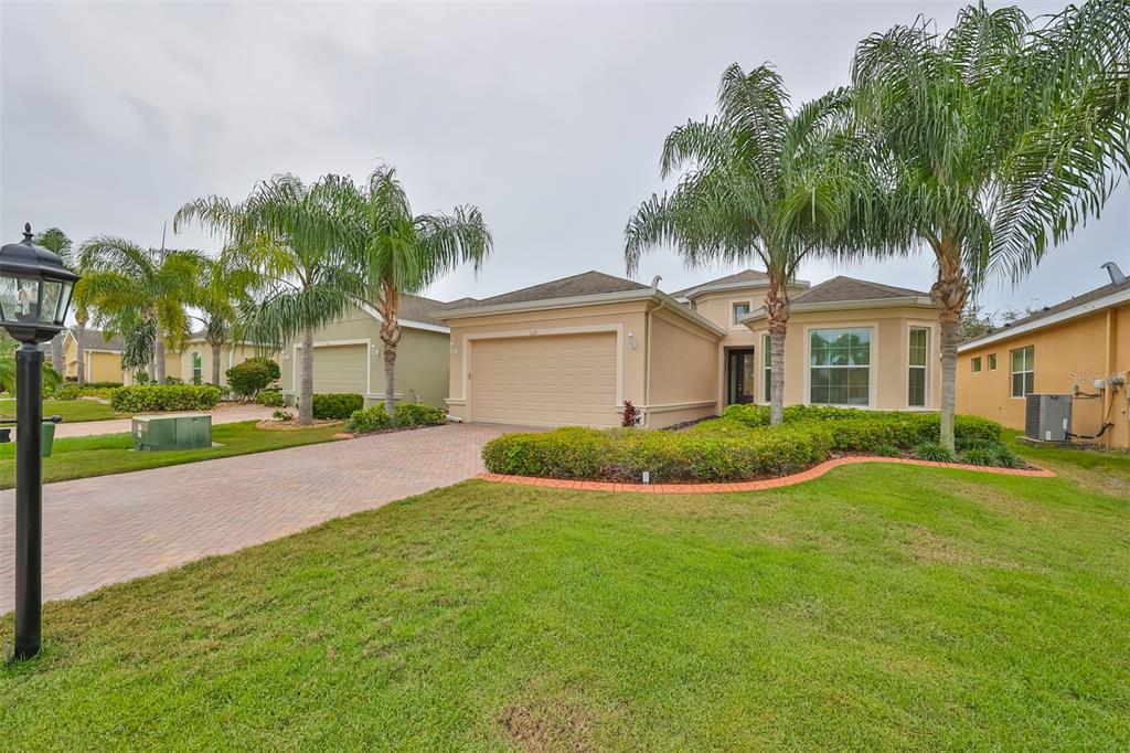 CONTEMPORARY and elegant single family home with a large driveway that has custom pavers, beautiful landscape curbing, low maintenance landscaping and NEW sod.