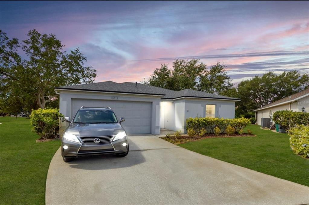 a car parked in front of a house with a garden