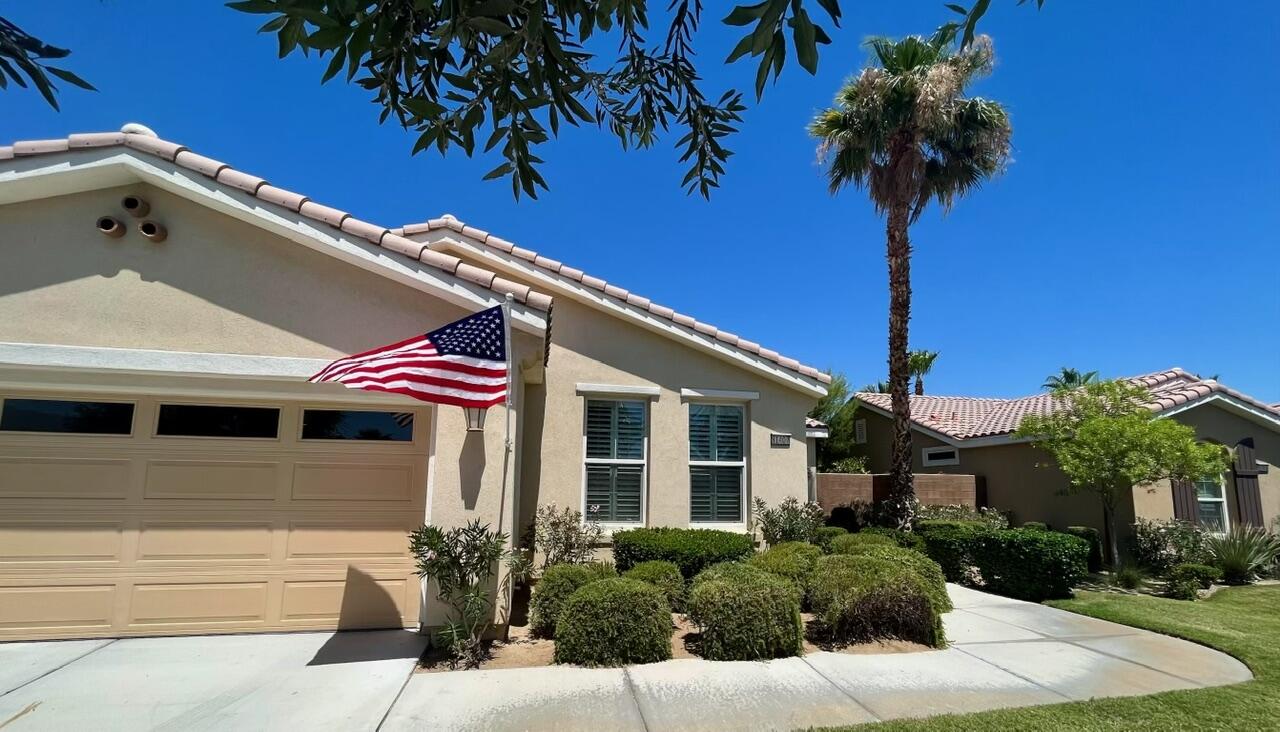 a front view of a house with plants and palm tree