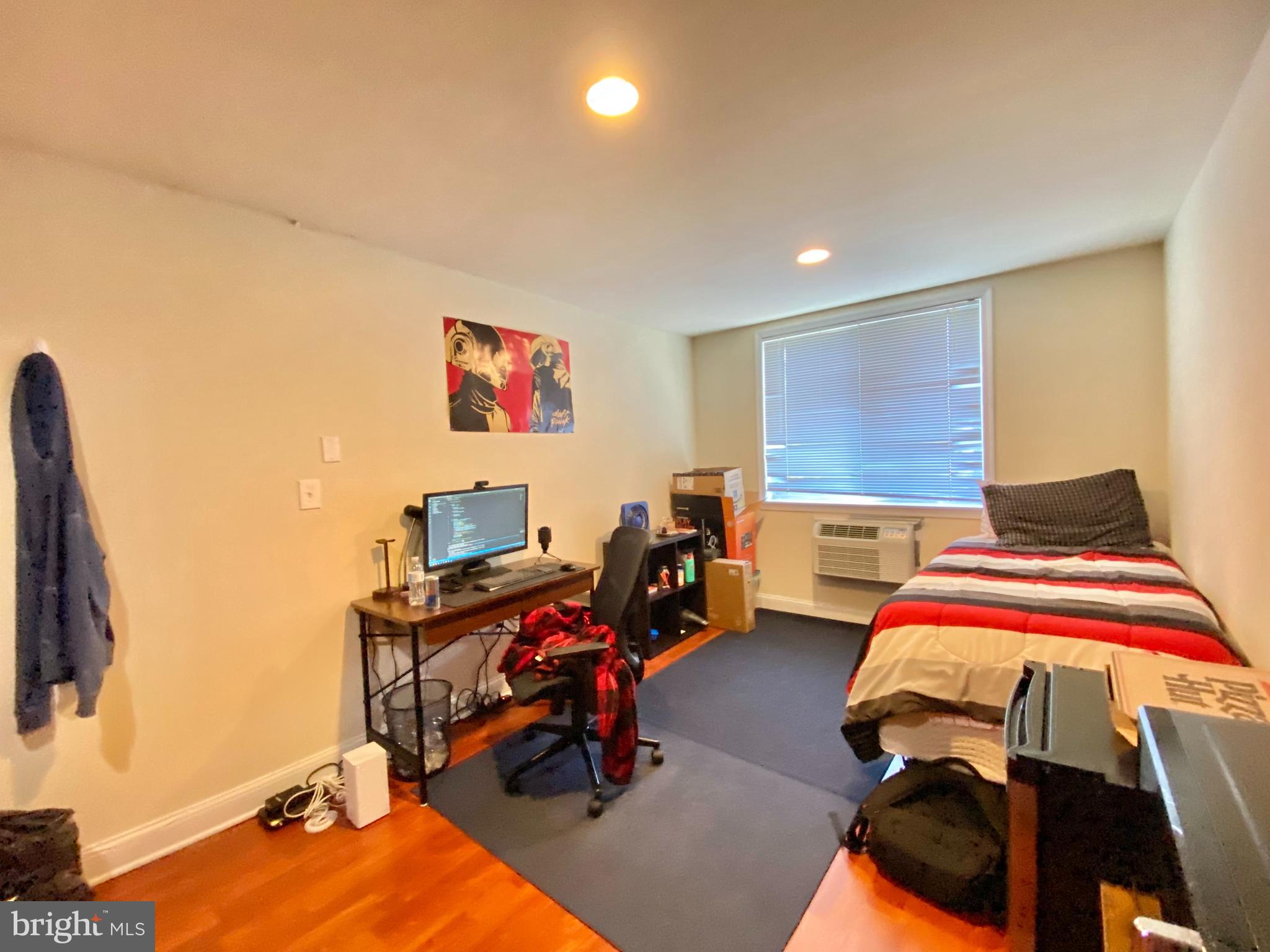 a bedroom with bed and a flat tv screen