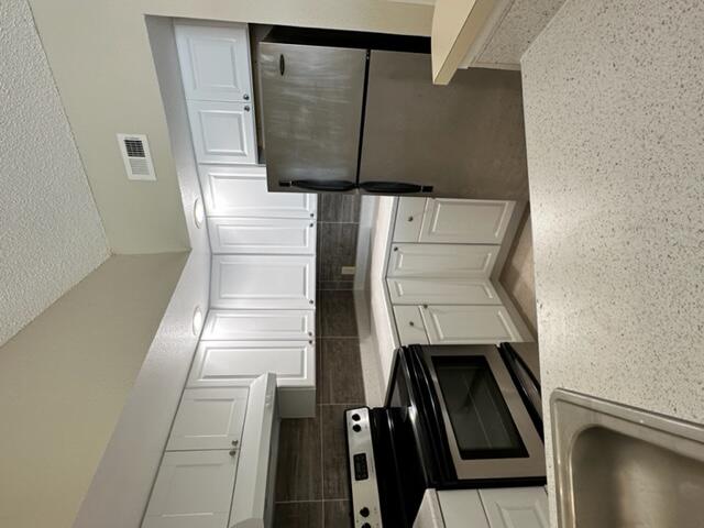 a kitchen with a refrigerator sink and cabinets