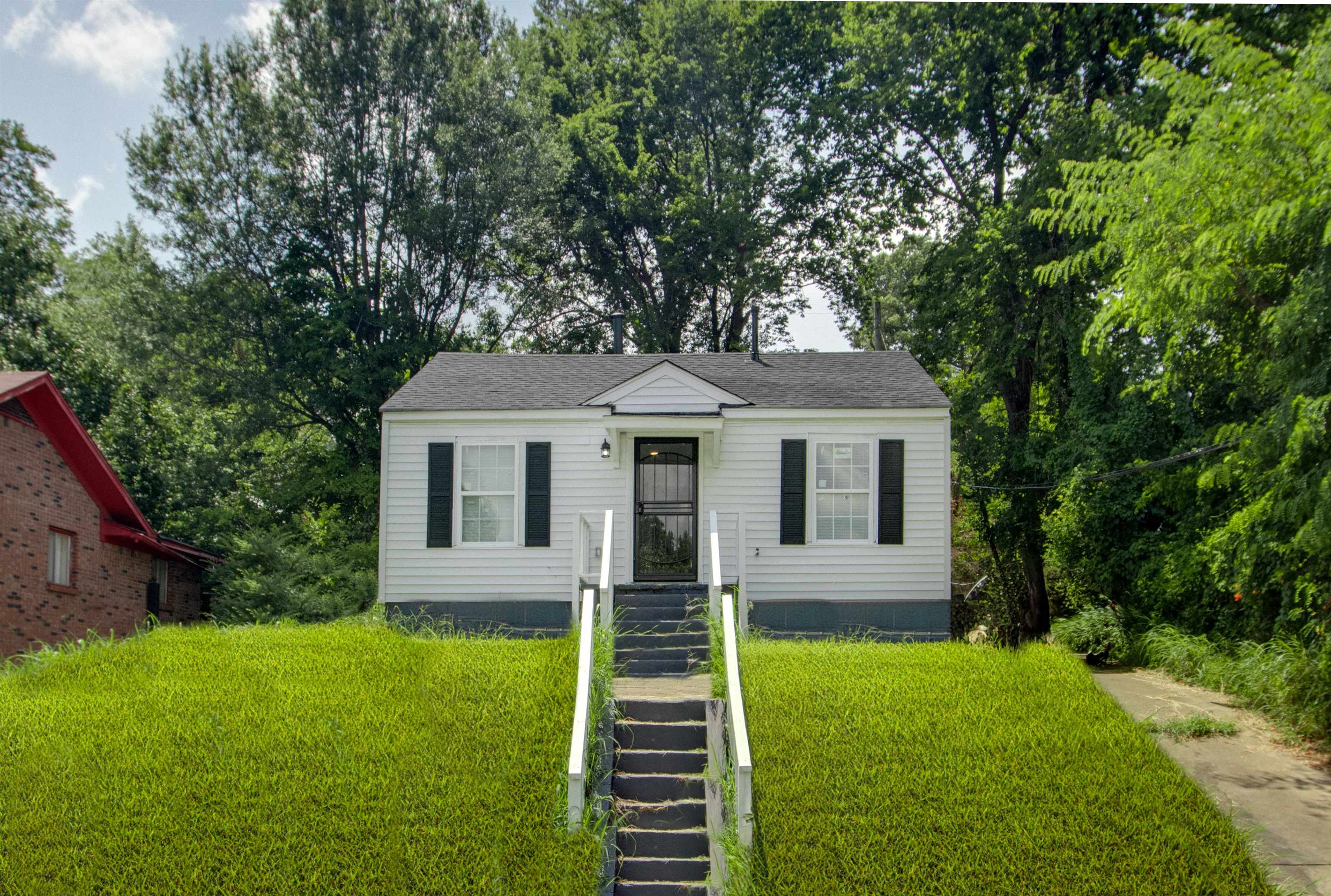 a front view of a house with a garden