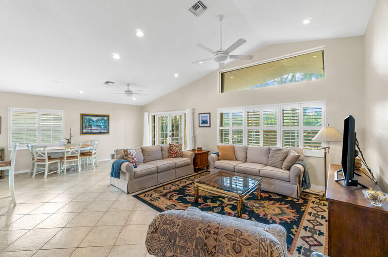 a living room with furniture a flat screen tv and a large window