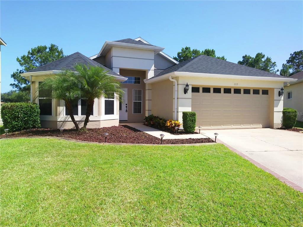 a front view of a house with a garden and plants