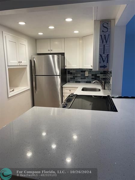 a kitchen with a refrigerator and a sink