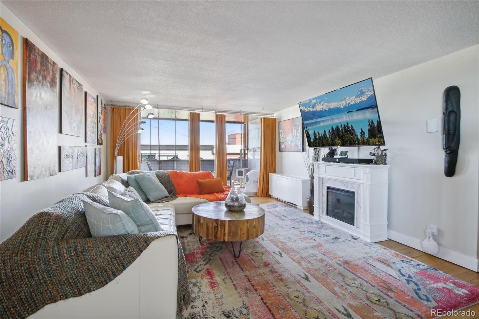 a living room with furniture a flat screen tv and a fireplace