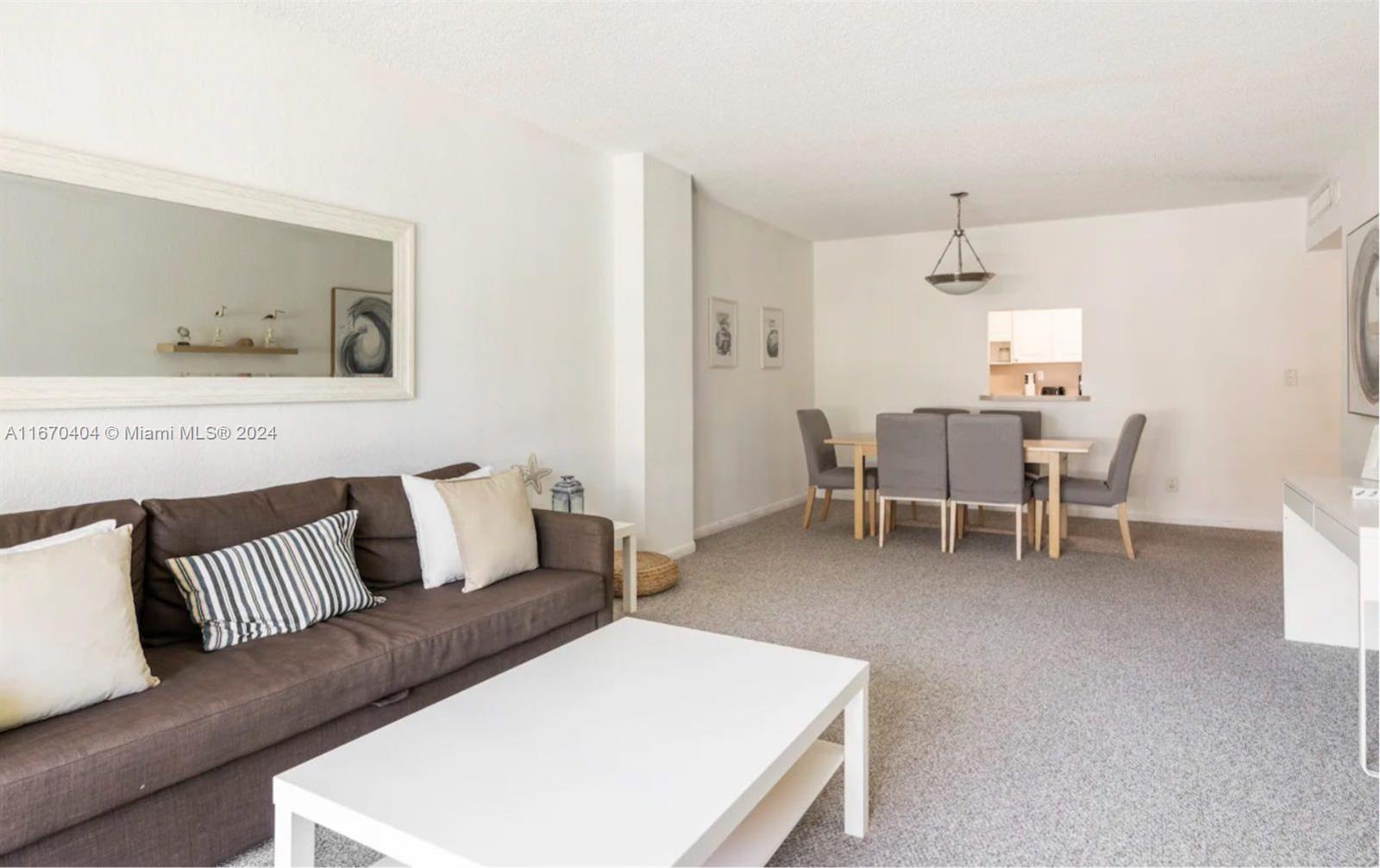 a living room with furniture and a dining table