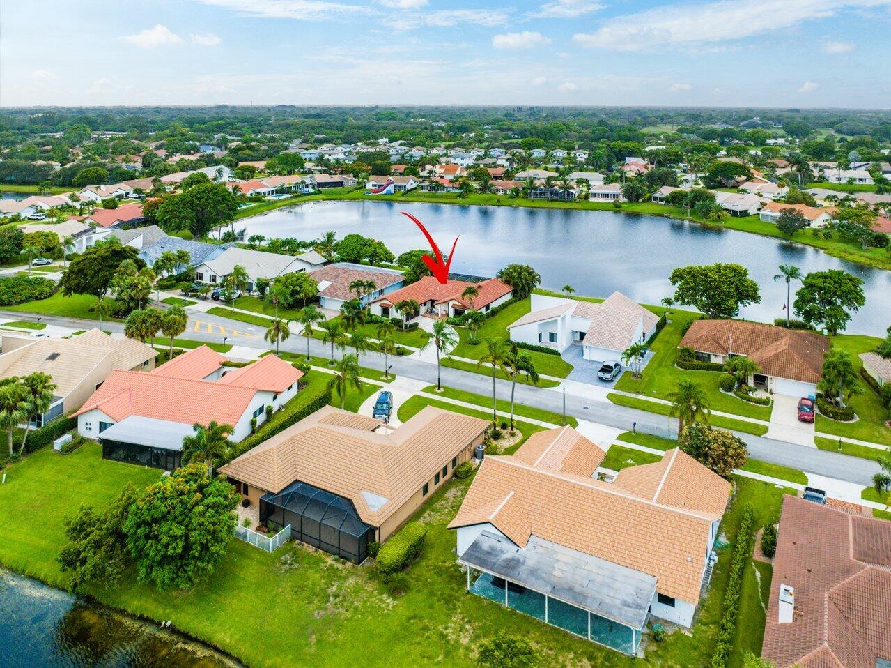 an aerial view of residential houses with outdoor space and lake view in back