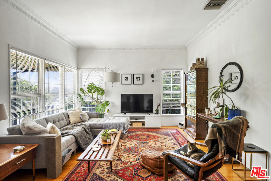 a living room with furniture a flat screen tv and a floor to ceiling window