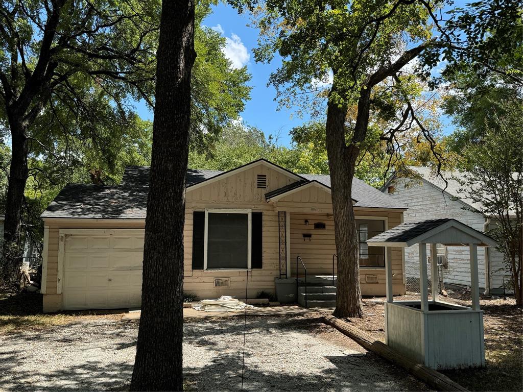 a front view of a house with a tree