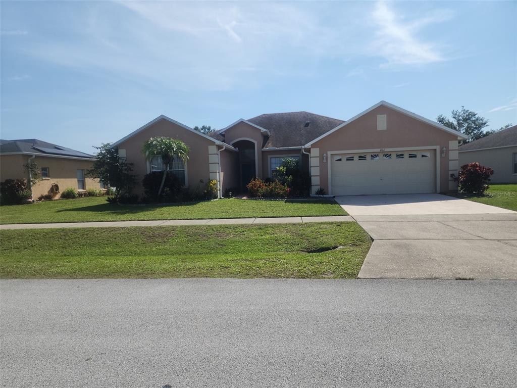 a front view of a house with a yard and garage