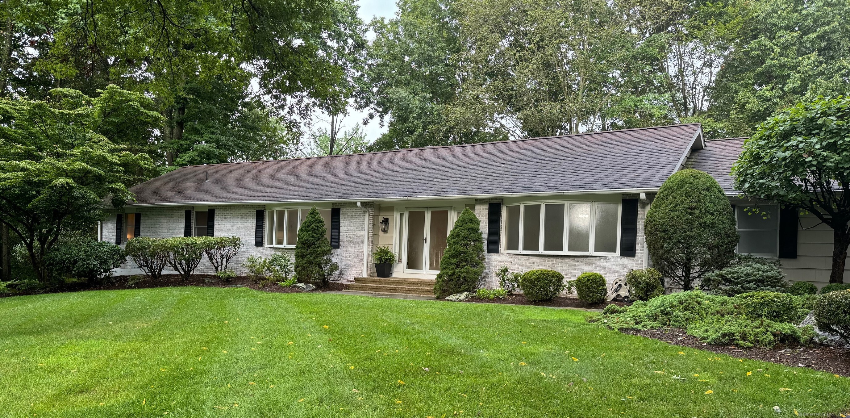 a front view of a house with a yard and trees