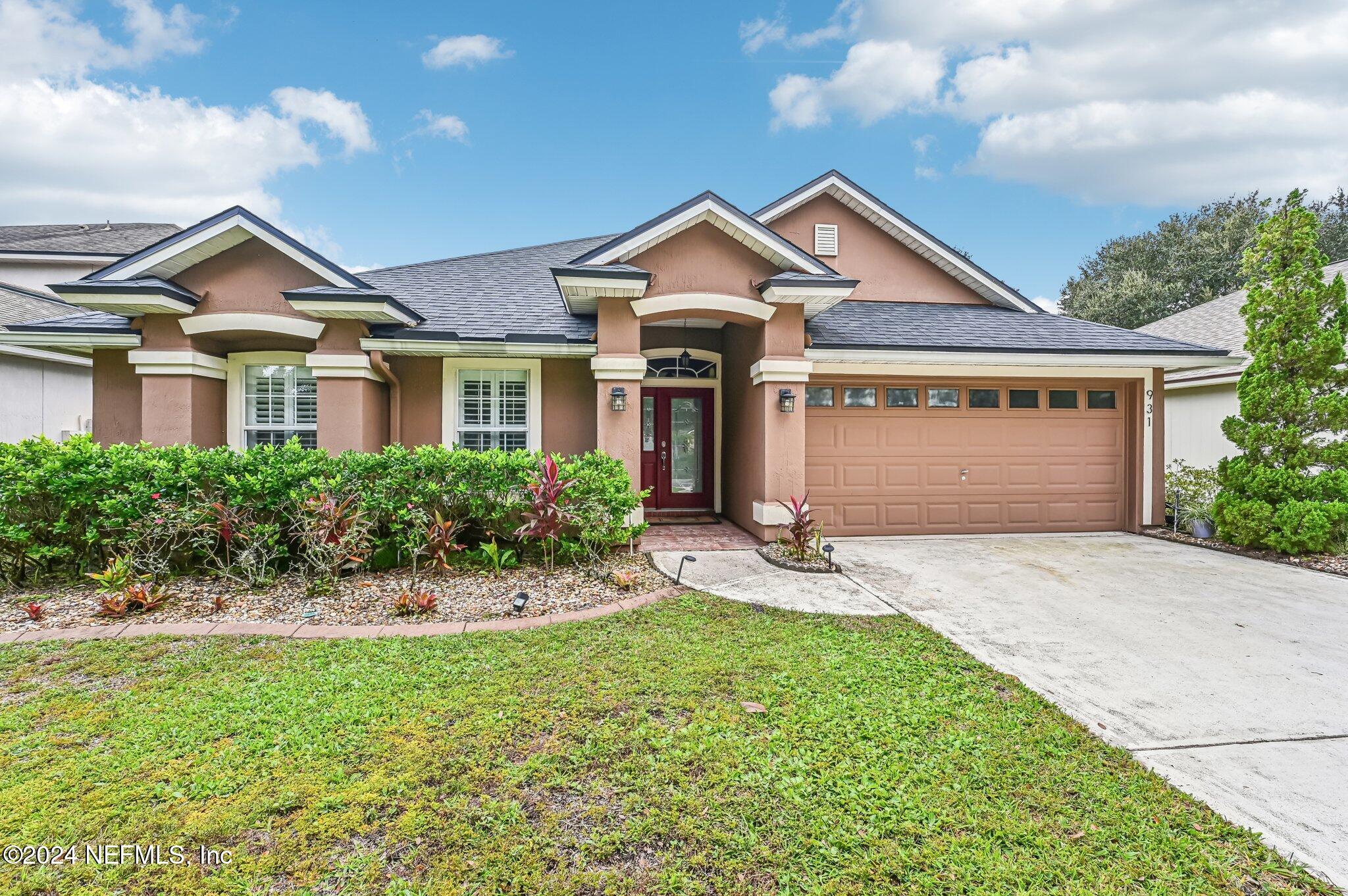 a front view of a house with a yard and garage