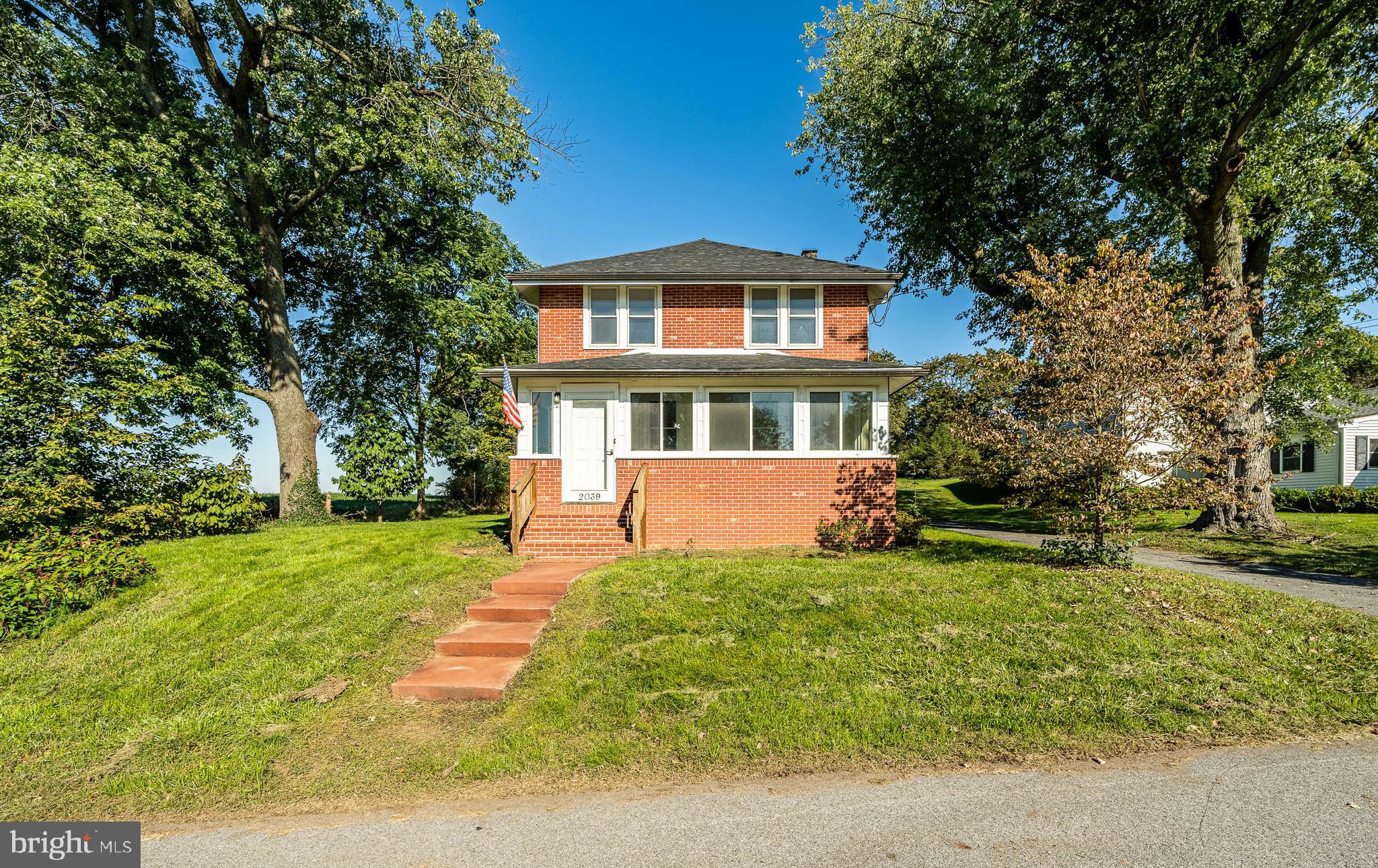 a front view of a house with a yard table and trees