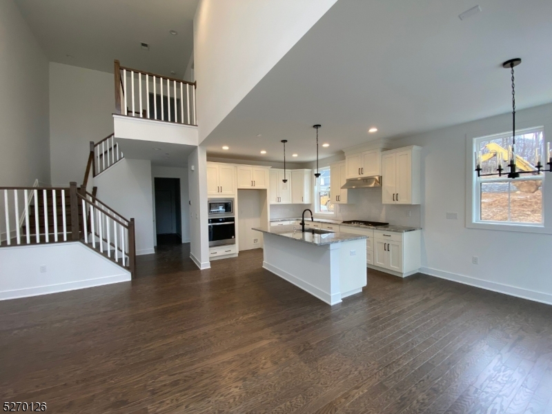 a kitchen with stainless steel appliances kitchen island a white cabinets and a couch