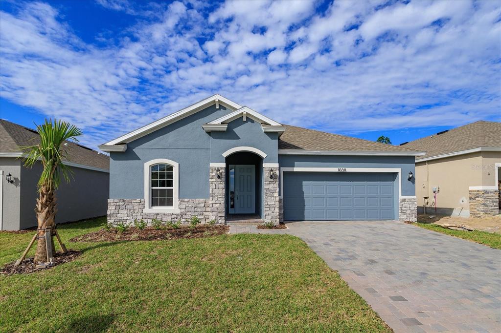 a front view of a house with a yard and garage