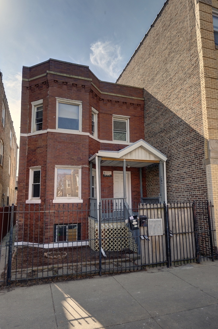 a front view of a house with iron fence