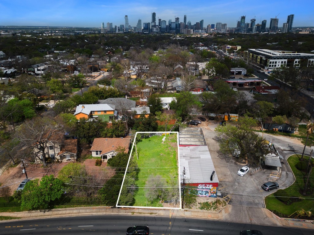 an aerial view of residential houses with outdoor space and parking