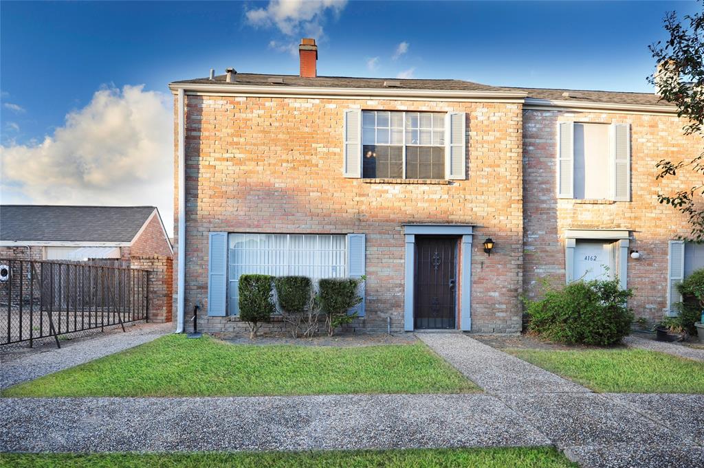 a front view of a house with a garden and yard