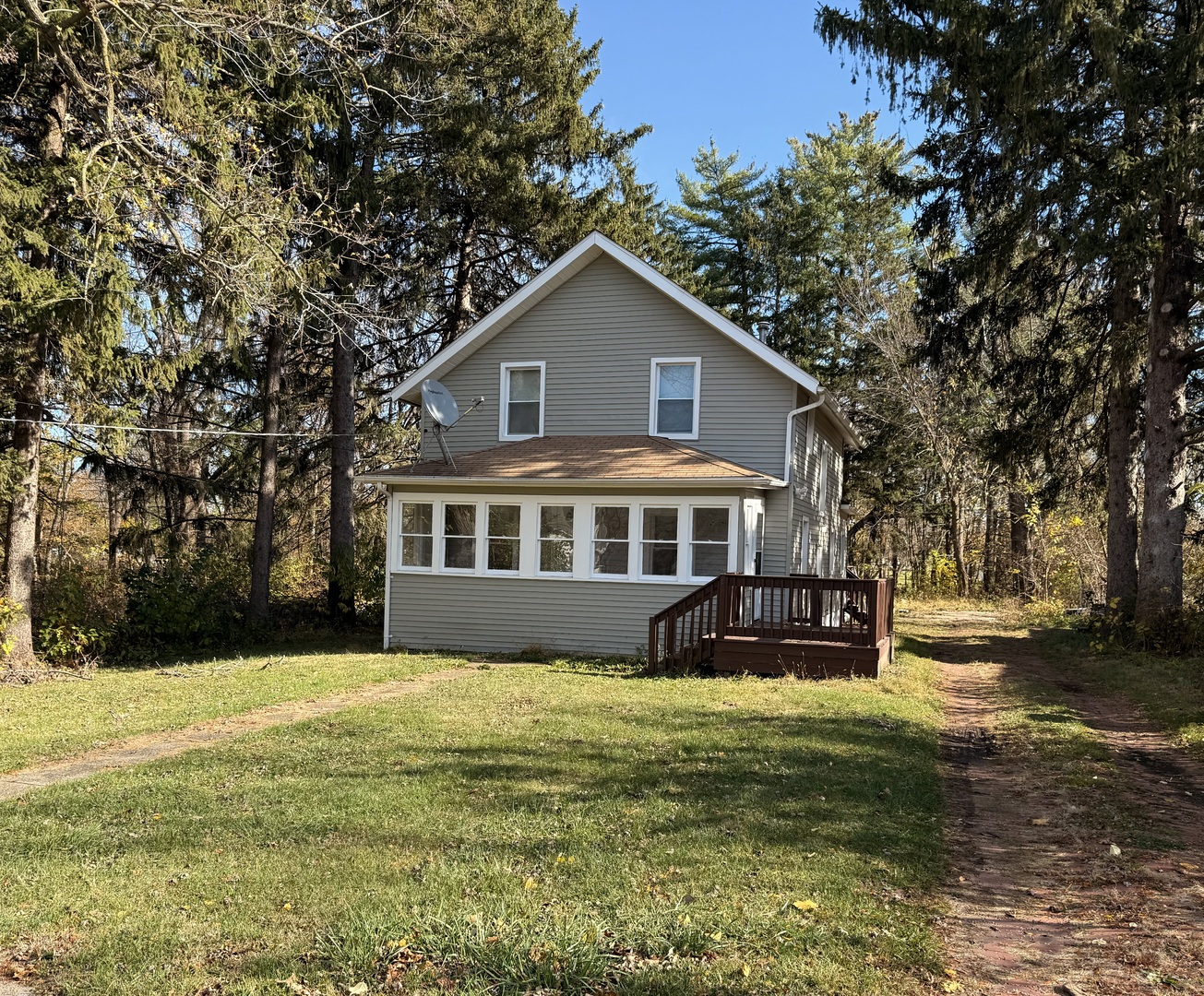 a front view of a house with a garden and trees