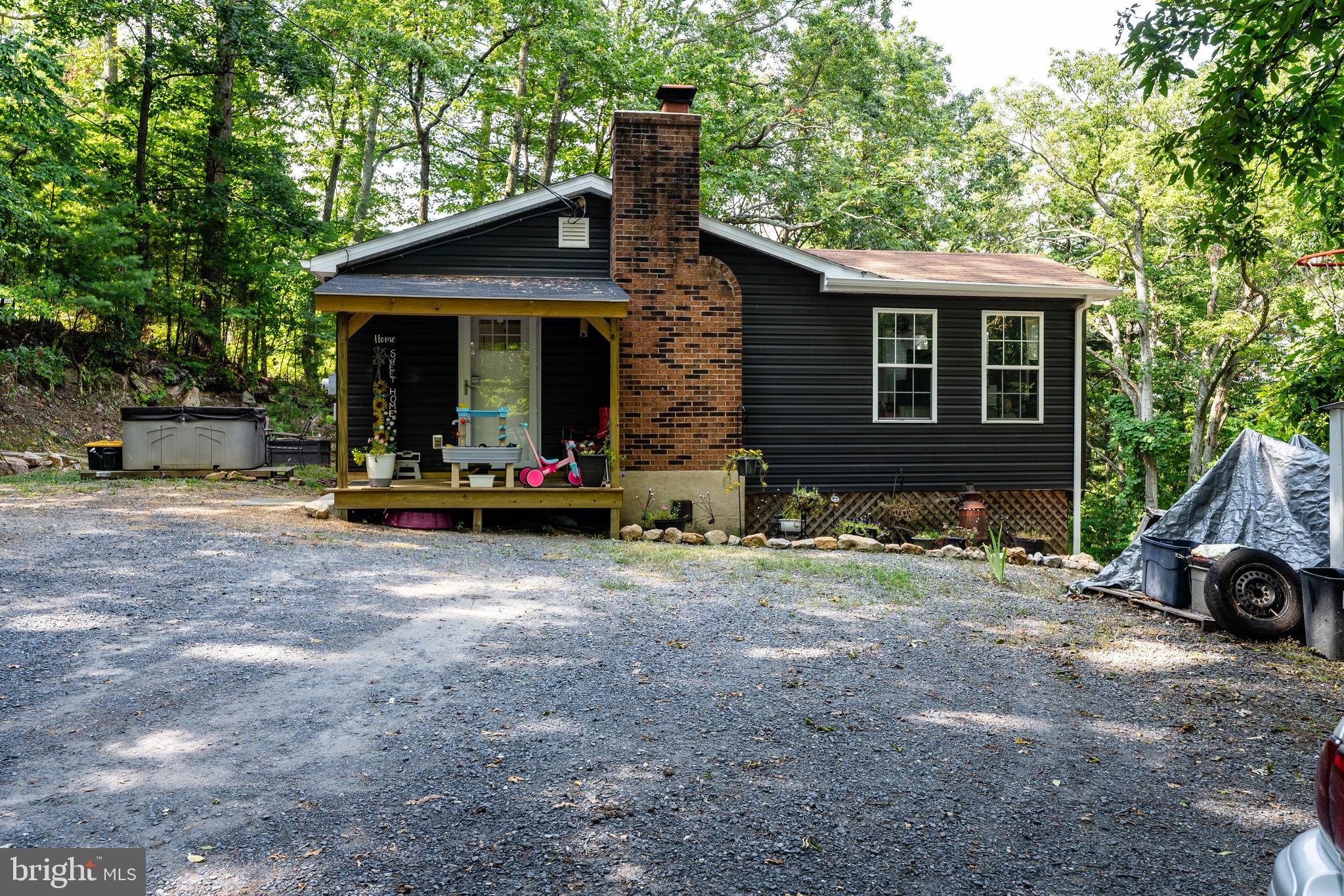 a front view of a house with a garden and trees