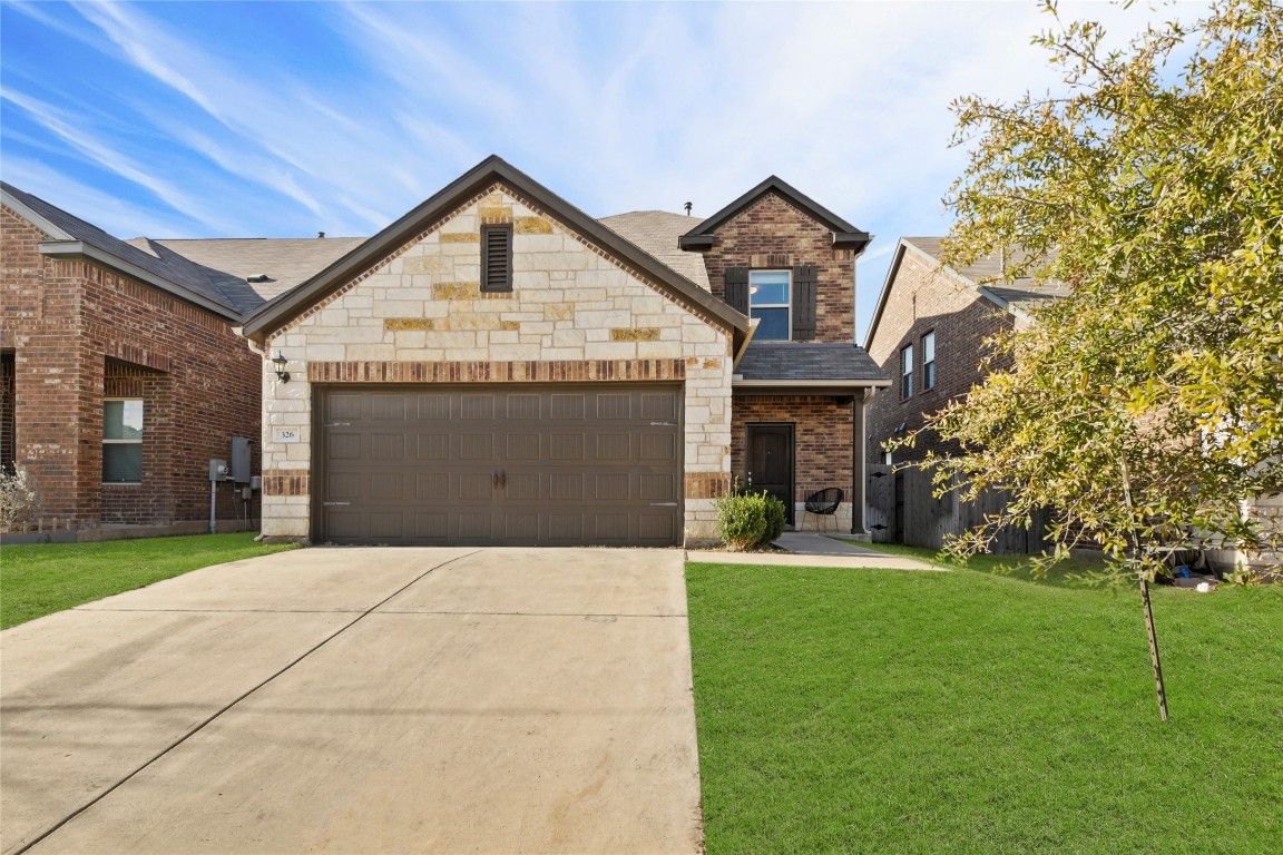 a front view of a house with a yard and garage