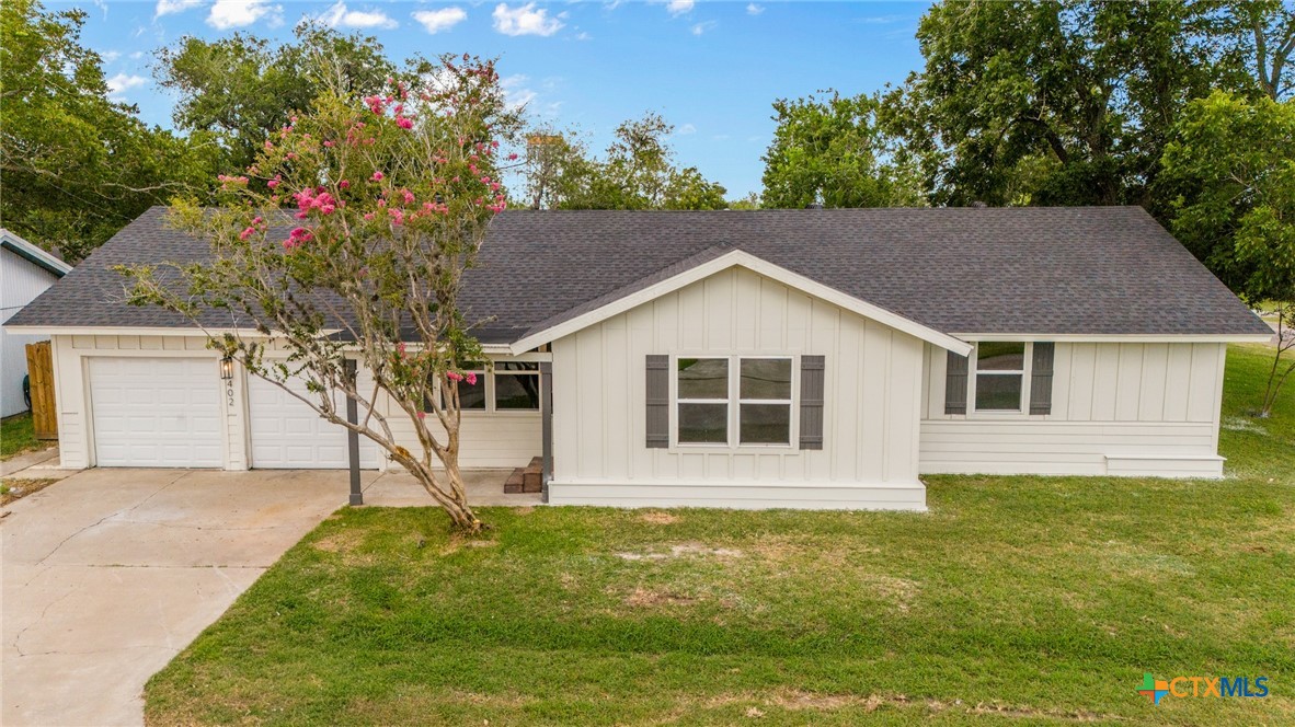 a view of a house with a yard and garage