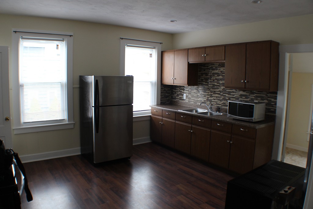 a kitchen with a refrigerator and a stove top oven