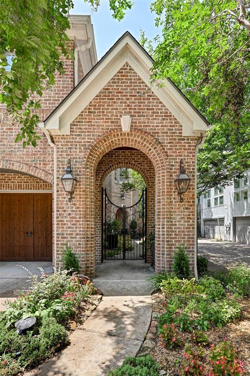 Experience timeless elegance in this two-story brick residence. The home features an inviting arched entryway with custom ironwork, a charming Juliet balcony, and a spacious two-car garage with artisan wood doors. A meticulously landscaped approach, adorned with classic gas lanterns, creates an atmosphere of sophistication and seclusion.