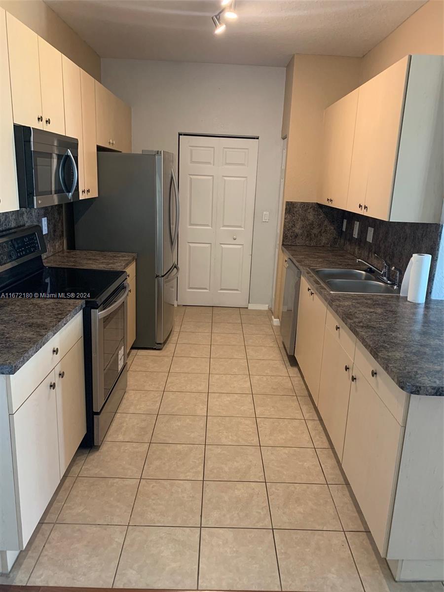 a kitchen with stainless steel appliances granite countertop a refrigerator and a stove