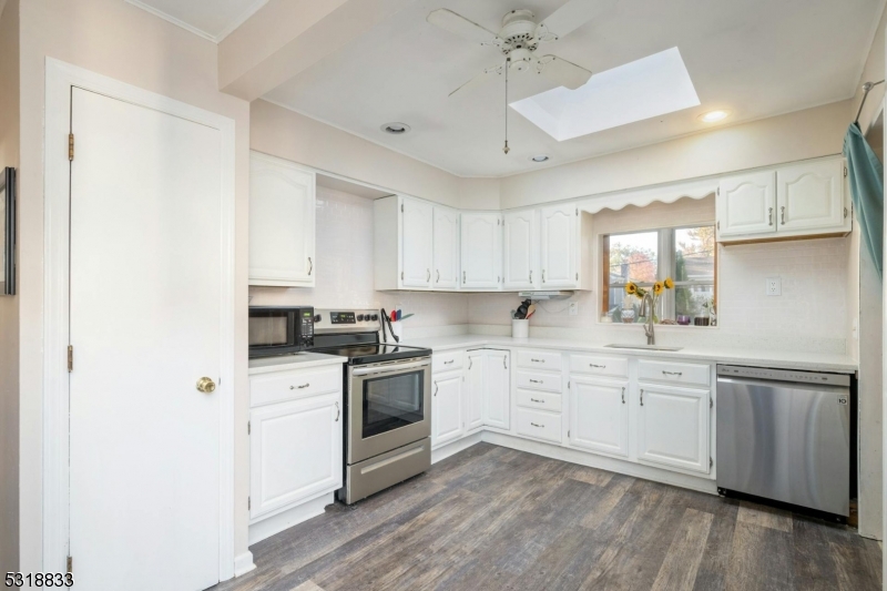 a kitchen with granite countertop white cabinets and white appliances