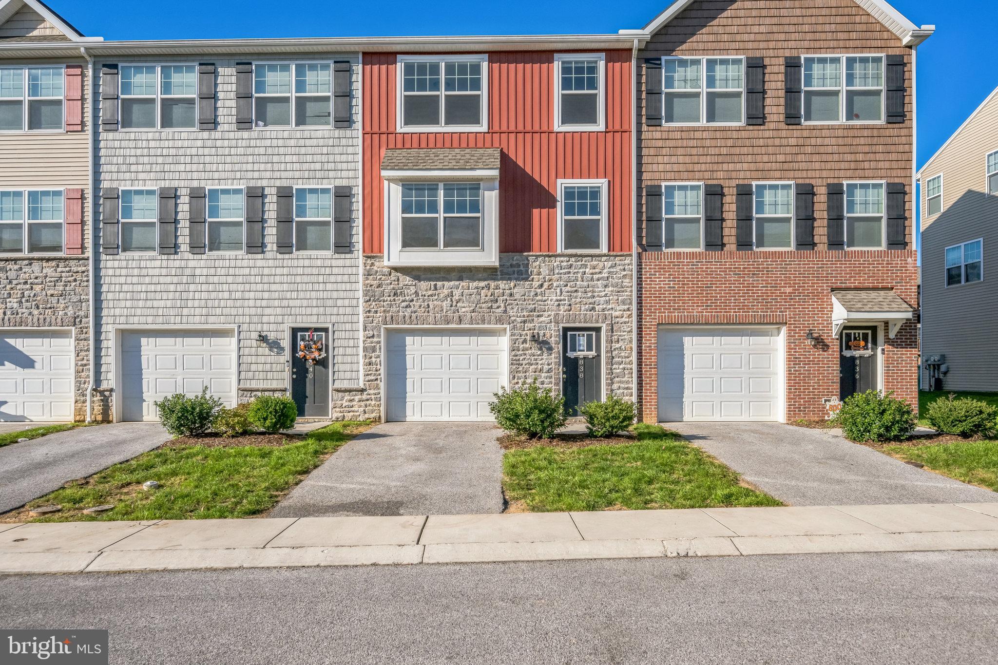 a front view of a house with yard and parking